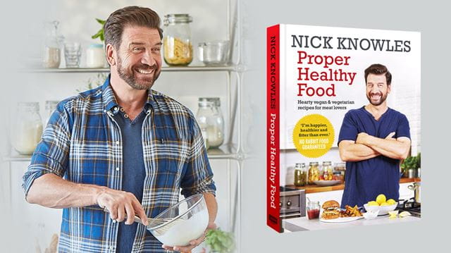 Nick Knowles cooking with an image of his book next to him